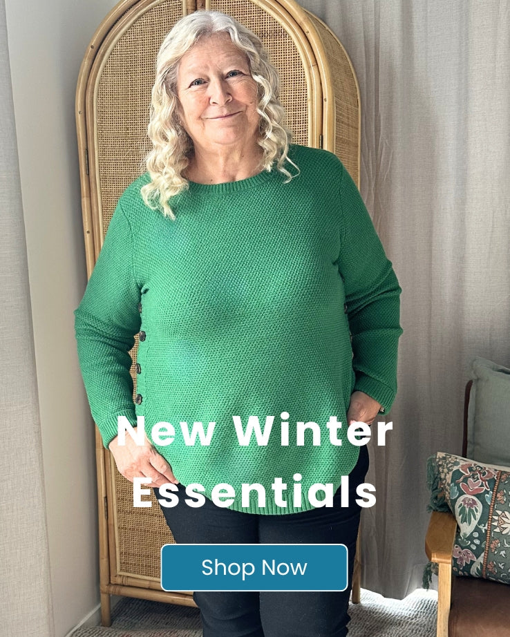 Woman wearing a green sweater with text 'New Winter Essentials' and 'Shop Now' in a home setting.