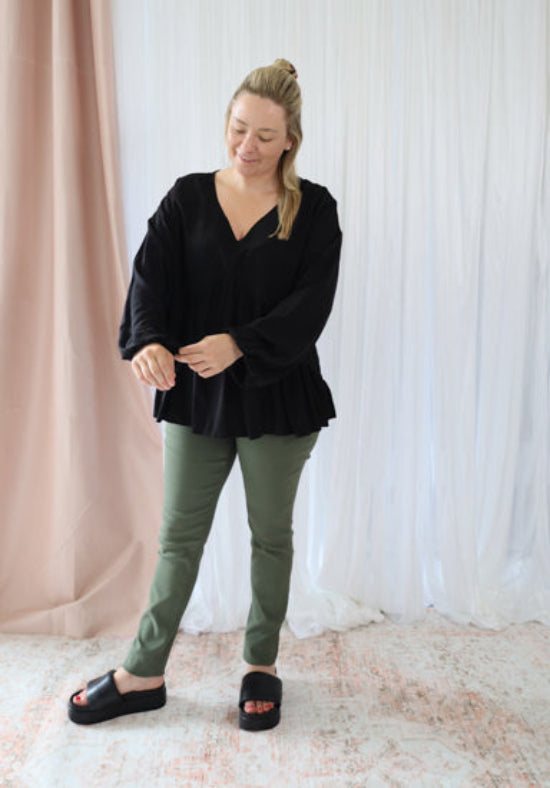 Black long sleeve top from Daisy's Closet Remi collection, featuring a fitted design and stylish neckline.