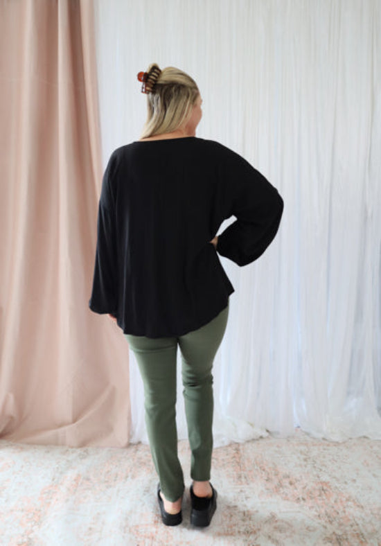 Black Remi long sleeve top from Daisy's Closet featuring a fitted design and ribbed fabric.