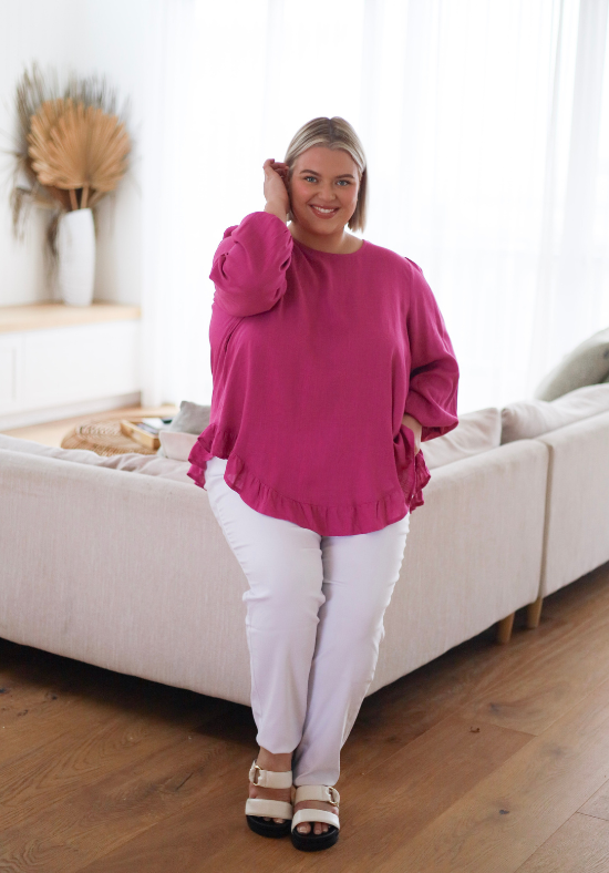 Ladies Long Sleeve Button Back Top - Magenta - Curved Neckline - Curved Hemline front and back - Size XL/XXL Front sitting view showing sleeve detail paired with white delta denim jeans  - Daisy's Closet Mila Magenta Top